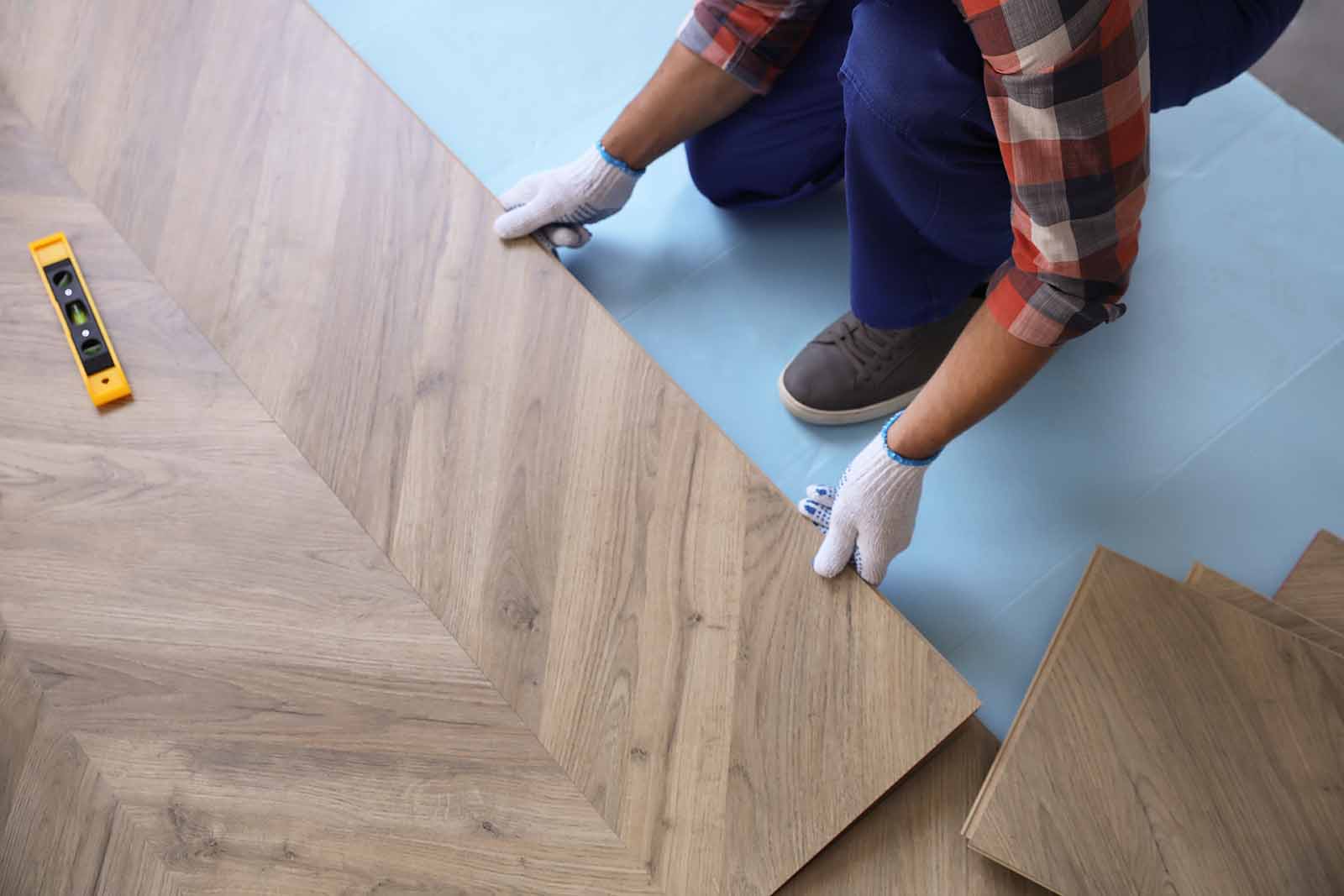 Person holding panels of wood flooring
